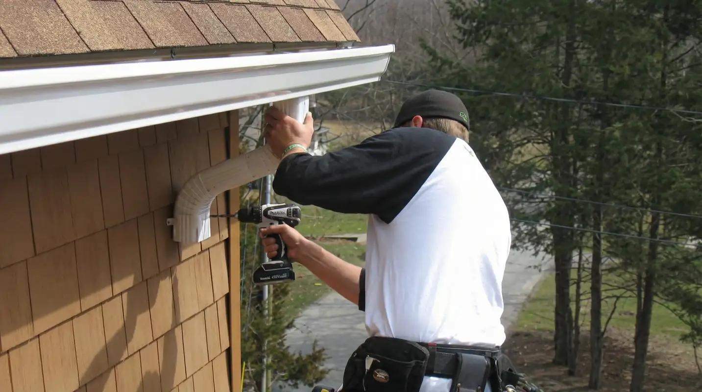 Professional contractor installing tan vinyl siding panels on a residential home exterior in Charlotte, NC